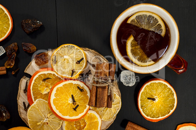 Black tea in a brown earthenware mug with slices of fruit