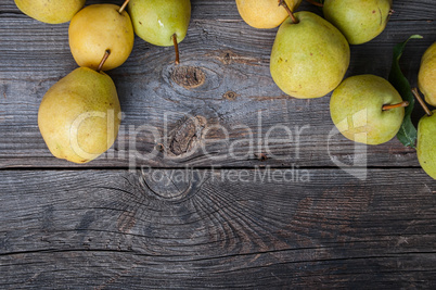 Ripe green pears on gray worn wooden background, top view