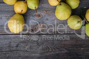 Ripe green pears on gray worn wooden background, top view