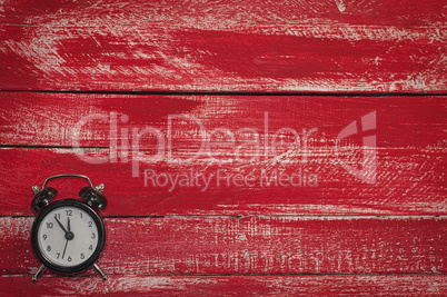 Old black clock on wooden red background