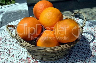 Several oranges bios in a basket in wicker.