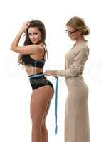 Tailor measuring waist of athletic woman