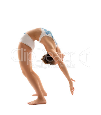 Young female gymnast making exercises in studio