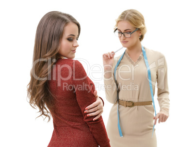 Young sexy dressmaker with her client studio shot