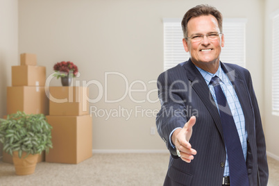 Businessman Reaching for Hand Shake in Room with Packed Boxes