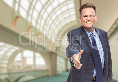 Businessman Reaching for Hand Shake Inside Corporate Building