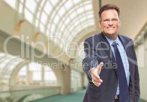 Businessman Reaching for Hand Shake Inside Corporate Building
