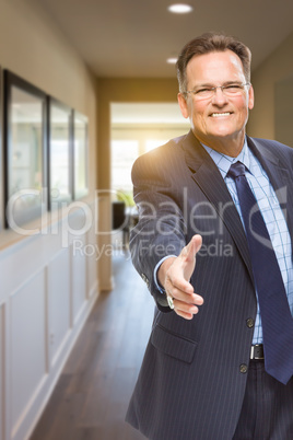 Male Agent Reaching for Hand Shake in Hallway of House