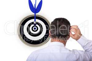 Man stands in front of dartboard