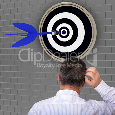 Man stands in front of dartboard