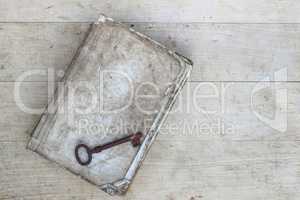 Old rusty key on torn book