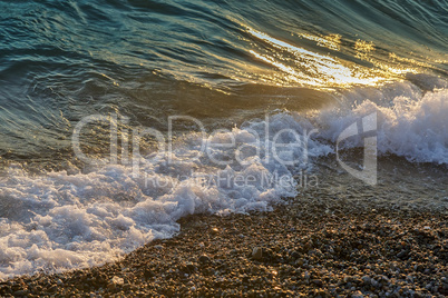 Surf wave on the beach in the evening.