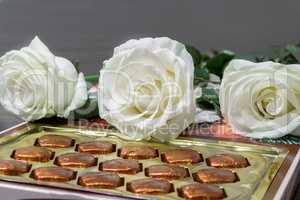 White roses and chocolates as a gift.