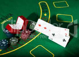 casino chips and a precious ring on green poker table background, man throws cards with losing combination.