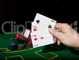 poker on a green table background, man holding losing combination of cards