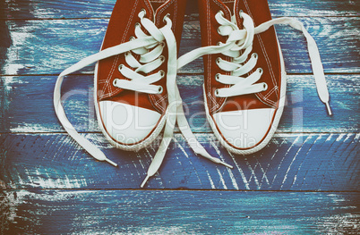 pair of red sneakers on a blue shabby wooden surface