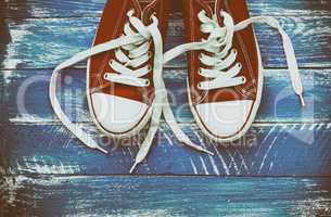 pair of red sneakers on a blue shabby wooden surface