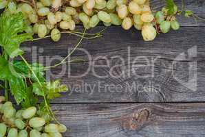 Bunches of white grapes on the gray wooden surface