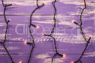 shabby wooden background with electric garland and burning light