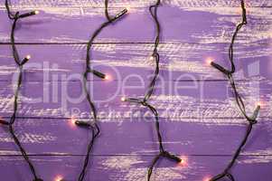 shabby wooden background with electric garland and burning light