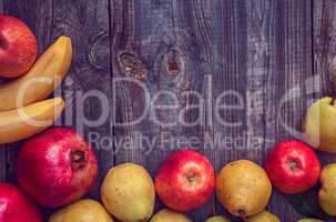 Ripe fruits lined frame on a gray wooden surface, empty space in