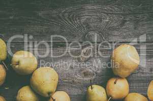 green pears on gray worn wooden background, top view