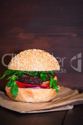 Hamburger with cutlet and vegetables served on paper