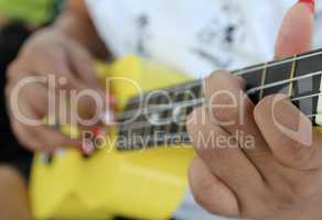 Closeup of a woman playing ukulele.