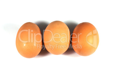 Three brown eggs isolated on white background.