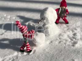 Small toys in the stage of building a snowman