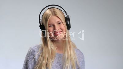 Teenage girl wearing headphones listens to music