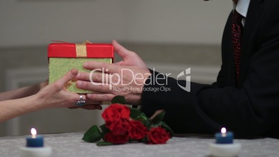 Senior male hands giving gift box to woman