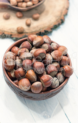 hazelnuts in the shell in brown clay bowl