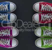 Four pairs of colorful sneakers youth on a black surface