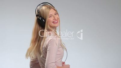 Happy smiling girl listening music in headphones