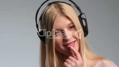 Playful teenage girl with earphones on white