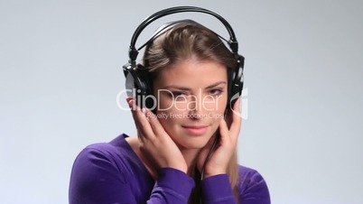 Lovely young woman listening music in headphones