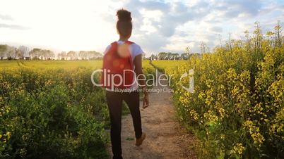 Mixed race African American girl teenager female young woman hiking with red backpack