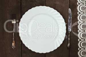 white plate with cutlery on a wooden surface
