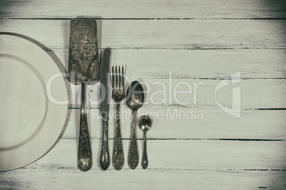 Vintage cutlery on a white wooden surface, empty space
