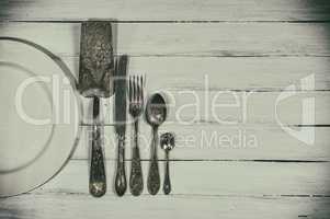 Vintage cutlery on a white wooden surface, empty space