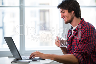 Graphic designer using laptop at his desk Graphic designer using laptop at his desk