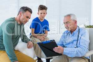 Doctor discussing reports with patient and his guardian
