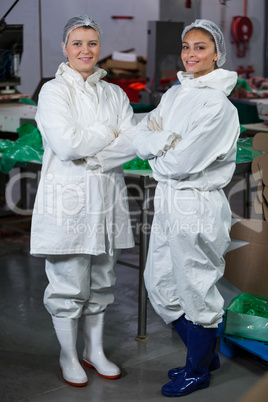 Female butchers standing with arms crossed