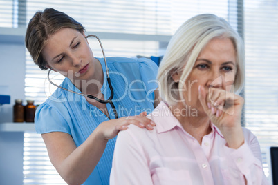 Doctor examining coughing patient