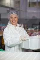 Female butcher holding container