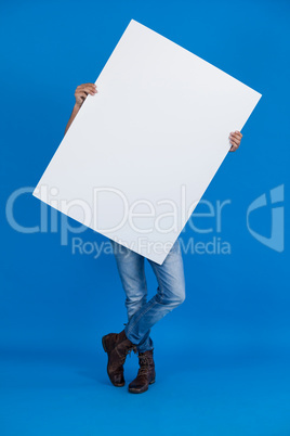 Man holding a blank placard in front of his face