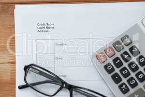 Paper document with calculator and spectacles