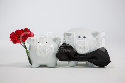 Two piggy bank with bunch of flower and bow bonding with each other