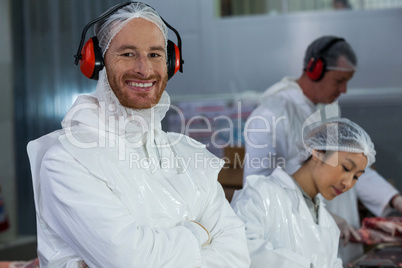 Smiling butcher in protective headphones